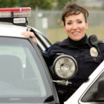 Female police officer next to patrol vehicle