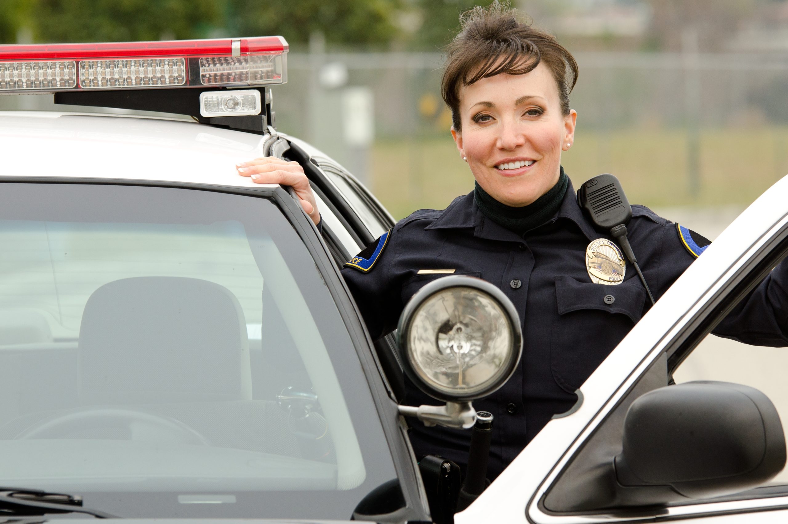 Female police officer next to patrol vehicle