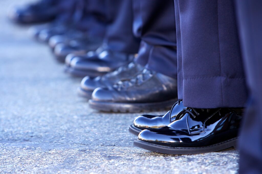 Line of police officers showing only their boots and bottom of the pants.