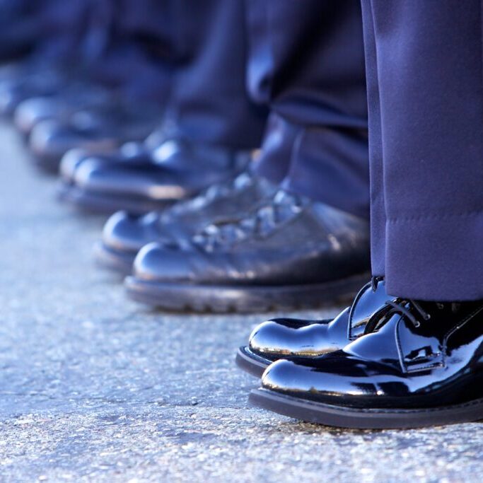 Line of police officers showing only their boots and bottom of the pants.